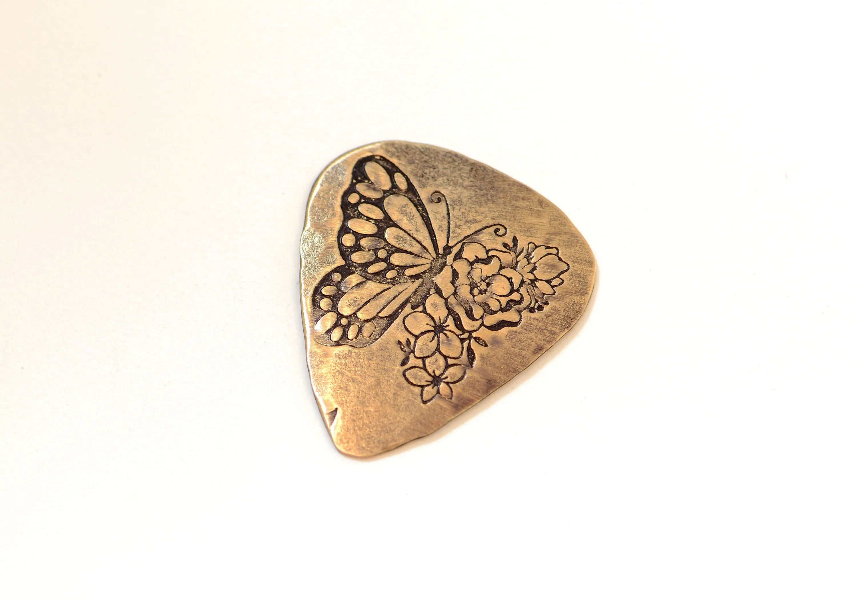 Bronze guitar pick with butterfly and flowers