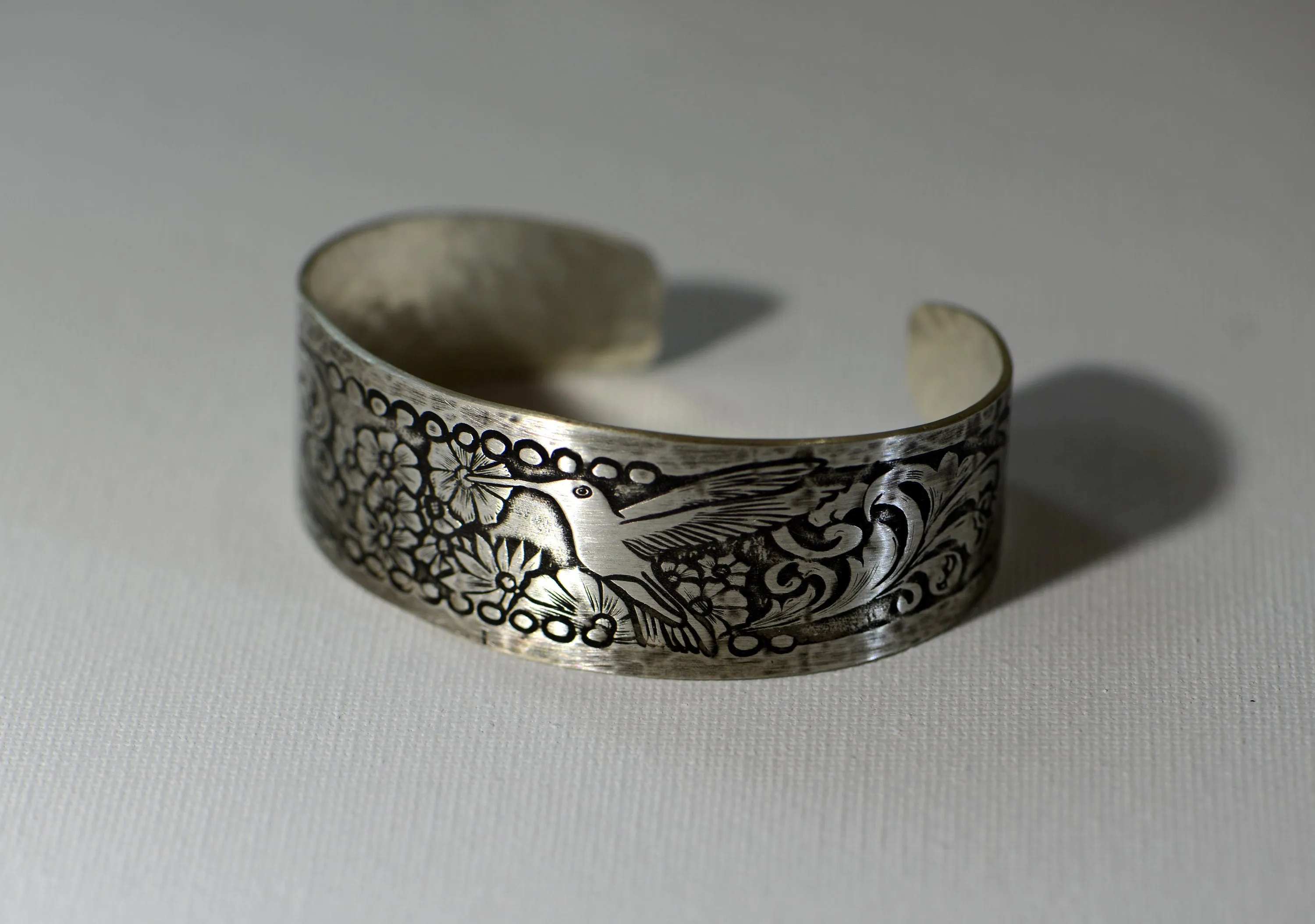 Hummingbird and flowers on a sterling silver cuff bracelet