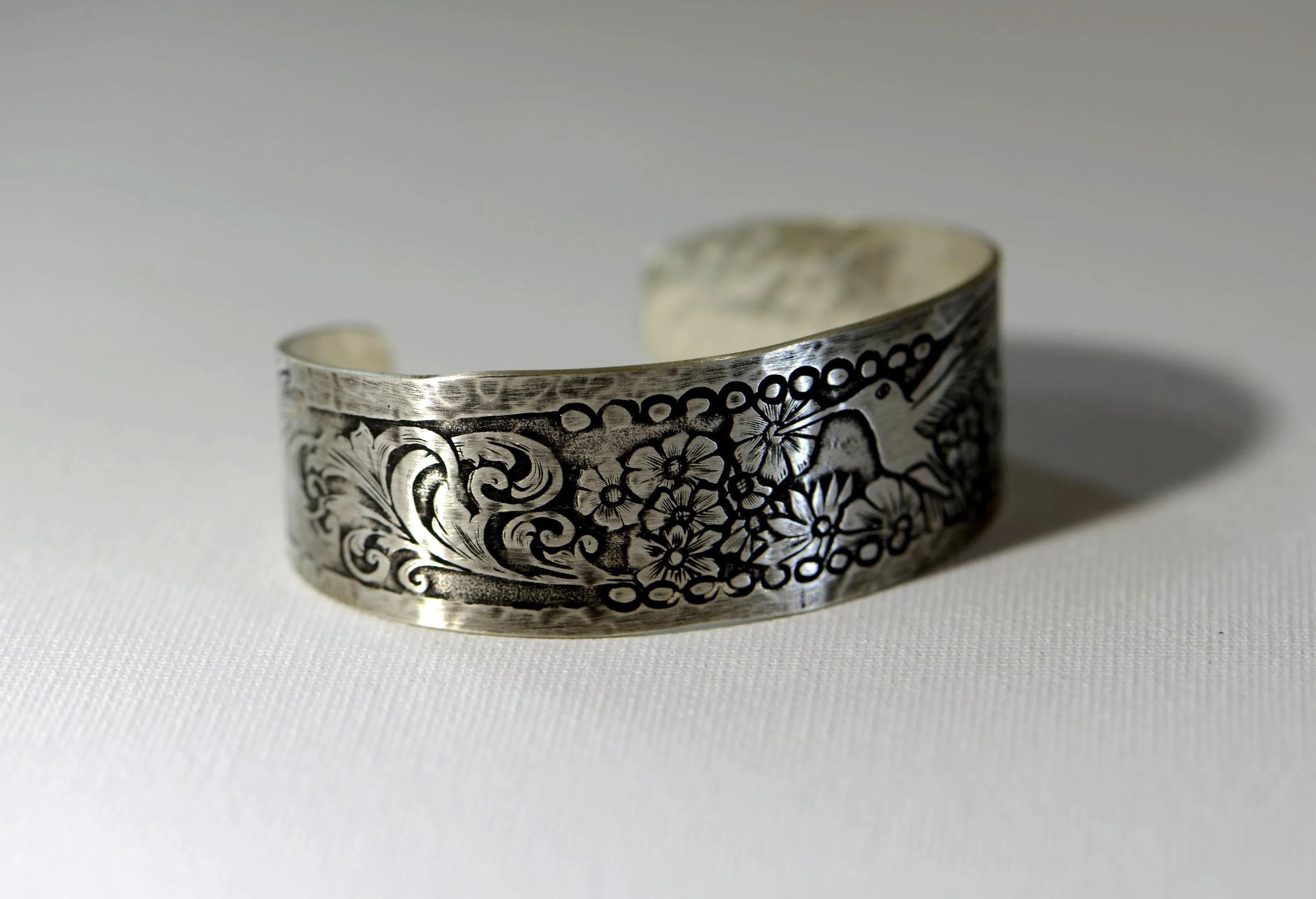 Hummingbird and flowers on a sterling silver cuff bracelet